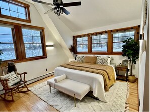 Relax in this inviting bedroom with a comfortable bed, plush bench, and cozy bedside table.