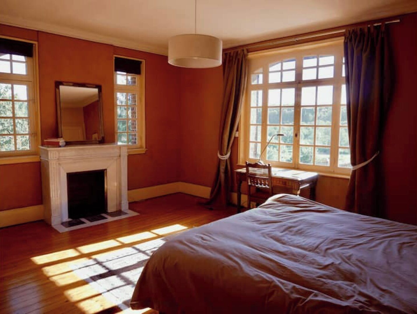 Une chambre à coucher avec une cheminée, un bureau et un lit.