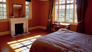 Une chambre à coucher avec une cheminée, un bureau et un lit.