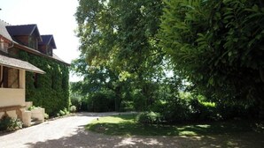Il s’agit d’une propriété résidentielle dotée d’une allée en gravier, d’une pelouse et d’un feuillage dense.