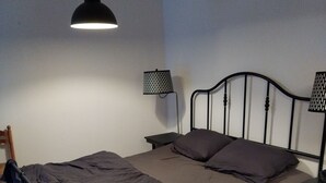 A single bed with a metal frame, a headboard, and two bedside tables with lamps. - Maisonnette mountain view (Roquefeuil)