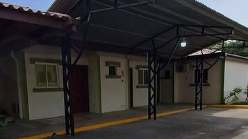 Un edificio con un acceso cubierto y un camino de entrada pavimentado.
