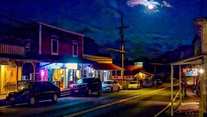 A street scene at night with buildings and cars.