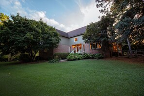A two-story house with a well-maintained lawn and a brick exterior.