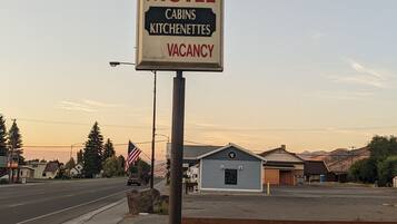 A motel sign with a horse and rider illustration, indicating a Bar H Motel with cabins and kitchenettes, and a vacancy.