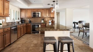 A modern kitchen with granite countertops, stainless steel appliances, and wooden cabinets. - Sparkling Pool, Poker Table, and Relaxation at Sweetwater (Scottsdale)