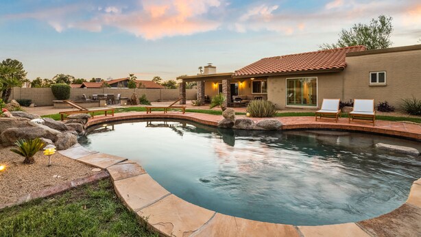 A residential swimming pool with a house in the background. - Sparkling Pool, Poker Table, and Relaxation at Sweetwater (Scottsdale)