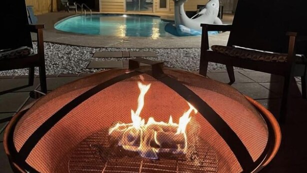 A poolside area with a fire pit and a shark statue. - Welcome to the Sunshine Shack in Corpus Christi! (Corpus Christi)