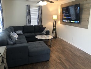 Relax in this cozy living space with a sectional sofa, coffee table, and flat-screen TV.
