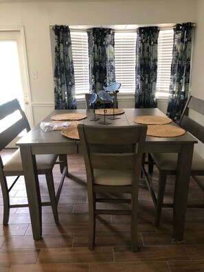 Enjoy meals with family and friends in this dining area, featuring a table for four and comfortable seating.
