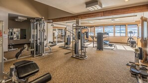 A gym with various exercise equipment, large windows, and a high ceiling. - Recently Renovated- Perfect for a Family Getaway! (Fraser)