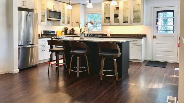 A modern kitchen with a central island, bar stools, stainless steel appliances, and pendant lighting. - Bloomington Indiana Rental- Entire House - 5 Bedrooms and 3 full bathrooms (Bloomington)