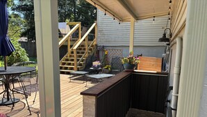 A wooden deck with outdoor furniture, a small staircase, and a potted plant. - Bloomington Indiana Rental- Entire House - 5 Bedrooms and 3 full bathrooms (Bloomington)