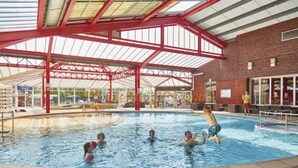 An indoor swimming pool with a covered roof and a brick wall. - 6 Berth Comfy Homely Caravan, Dog Friendly (Burgh Castle)