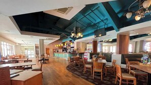 A spacious restaurant with high ceilings, wooden flooring, and a variety of seating arrangements including tables and booths. - 6 Berth Comfy Homely Caravan, Dog Friendly (Burgh Castle)