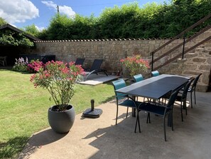 Enjoy the serene atmosphere of this outdoor patio area with a stone wall, stairs, and comfortable seating.