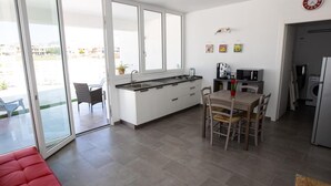 Eine moderne Küche mit Essbereich, großen Fenstern und einer roten Bank.