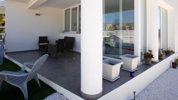 Eine moderne Außenpatio mit Sitzgelegenheiten und Pflanzgefäßen.