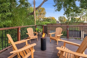 A deck with four wooden chairs and a central fire feature. - Westside Warehouse-Hot Tub/GameRM/PoolTable & More (Cleveland)