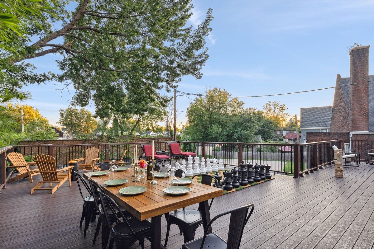 An outdoor deck with a dining table set for six, surrounded by chairs.