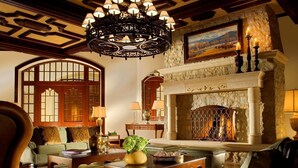 A cozy living room with a fireplace, a chandelier, and comfortable seating.