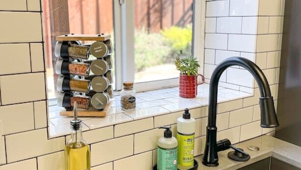A kitchen with a window, a sink, and a countertop with various items.