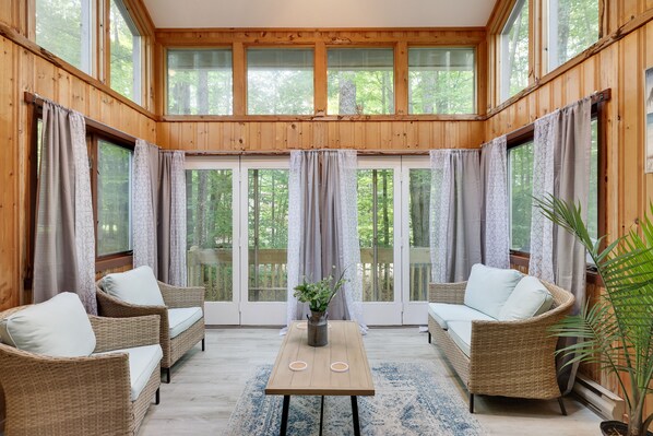 Relax in this spacious room with a large seating area, wicker sofas, and a sliding glass door leading to an outdoor deck.