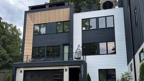Une maison moderne à deux étages, dotée d’un garage, d’une pelouse bien entretenue et d’une allée.