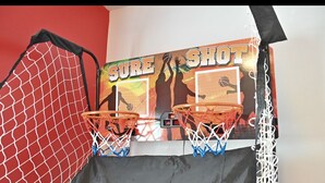 Een basketbalring met net, een basketbal en een poster met de tekst 'SURE SHOT'.