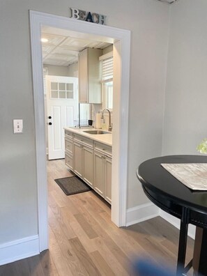 A kitchen with light-colored cabinets, a sink, and a door labeled 'BEACH'. - Everything you need! Steps to Beach-Margate-Restaurants-Stores -Sleeps 4 guests (Ventnor City)