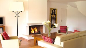 A living room with a fireplace, a sofa, a coffee table, and a TV.
