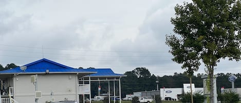 Um edifício comercial com teto azul, estacionamento e área de piquenique.