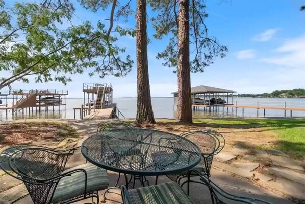 Une terrasse au bord du lac, avec des sièges extérieurs et une vue sur l’eau.