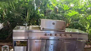 A stainless steel outdoor kitchen with a sink, a gas cylinder, and a built-in oven. - Birch Motel Tocumwal (Tocumwal)