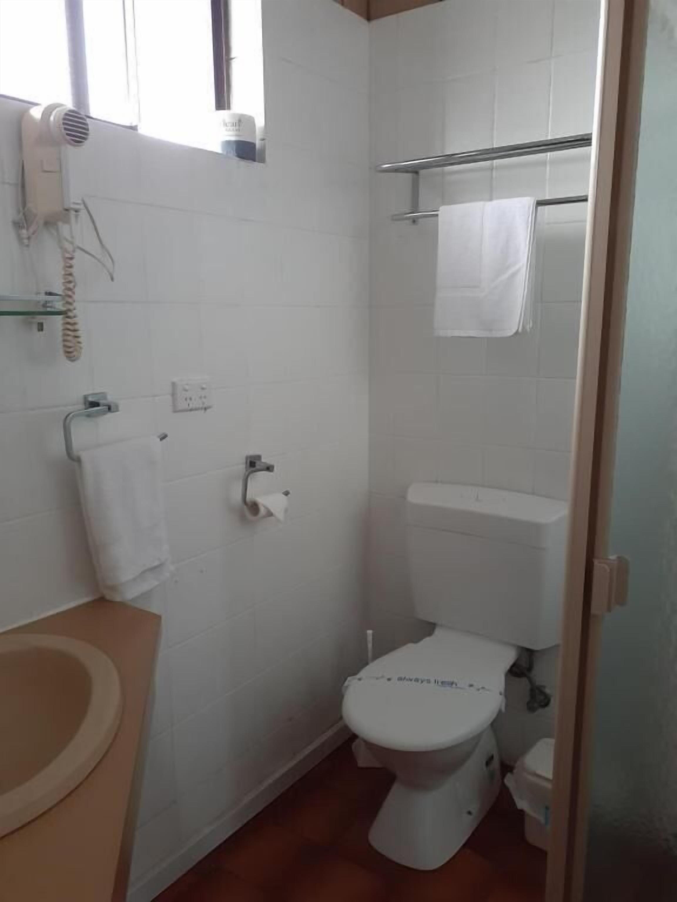 Un baño pequeño y funcional con inodoro, lavamanos y toallero.