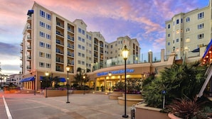 A hotel with multiple floors, outdoor seating, and a waterfront view. - Club Wyndham Resort 3 Bedroom Presidential Ocean View (Oceanside)