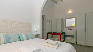 A bedroom with a bed, a nightstand, a dresser, a mirror, and a wardrobe. - Villa Les Oliveres Petites en Pollensa by Mallorca North Villas (Pollensa)