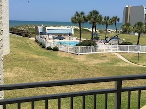A pool area with a white fence, palm trees, and a view of the ocean. - OCEAN FRONT! AMAZING VIEWS of beach and intercostal. Dock and boat ramp. (St. Augustine)
