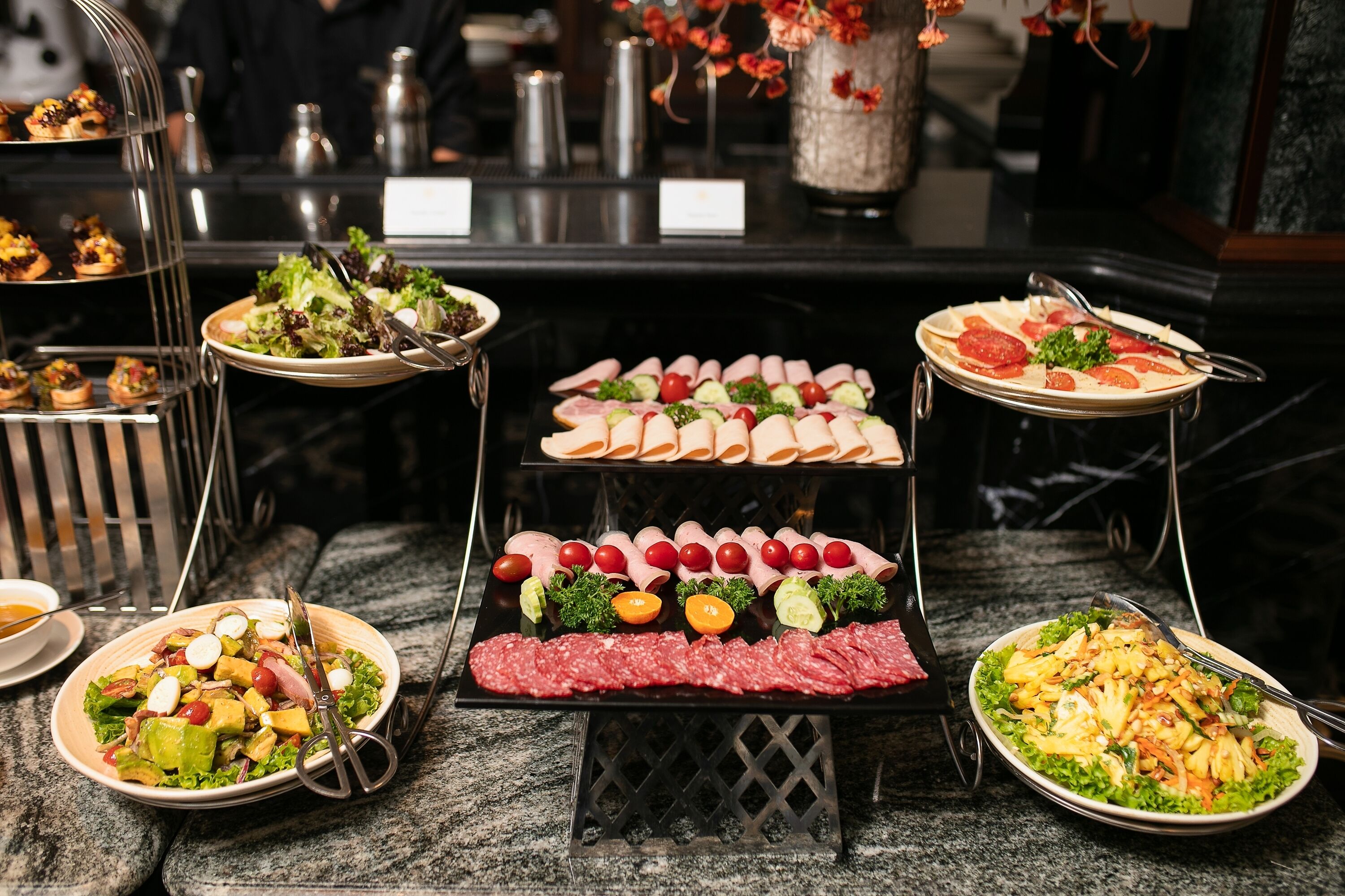 A buffet with various food items including salads, meats, and appetizers.