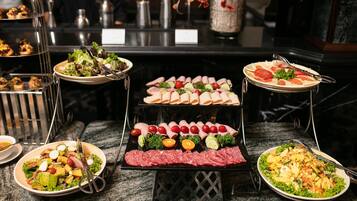 A buffet with various food items including salads, meats, and appetizers.
