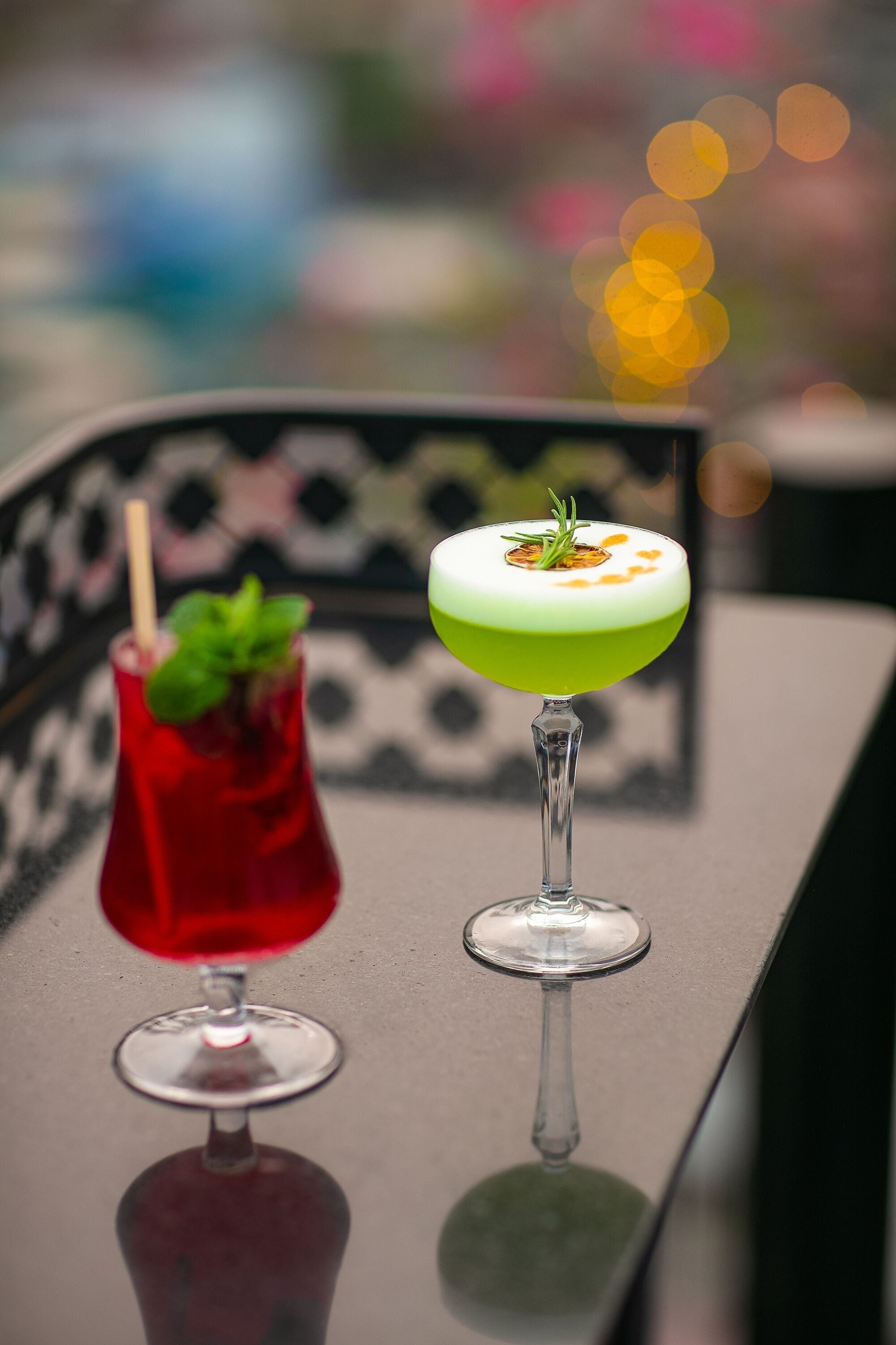 Two cocktails on a table with a blurred background.
