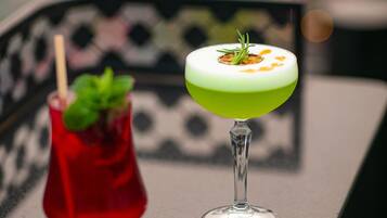 Two cocktails on a table with a blurred background.