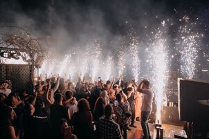 Evento multitudinario en interiores donde personas sostienen sus teléfonos, probablemente para capturar el momento.