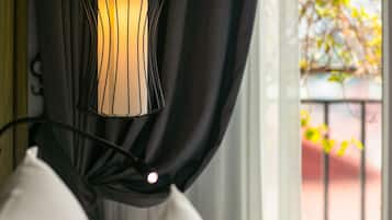 A close-up of a black metal lamp with a unique design, hanging from a curtain rod.