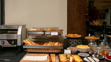A buffet with various food items, including bread, cheese, and pastries.