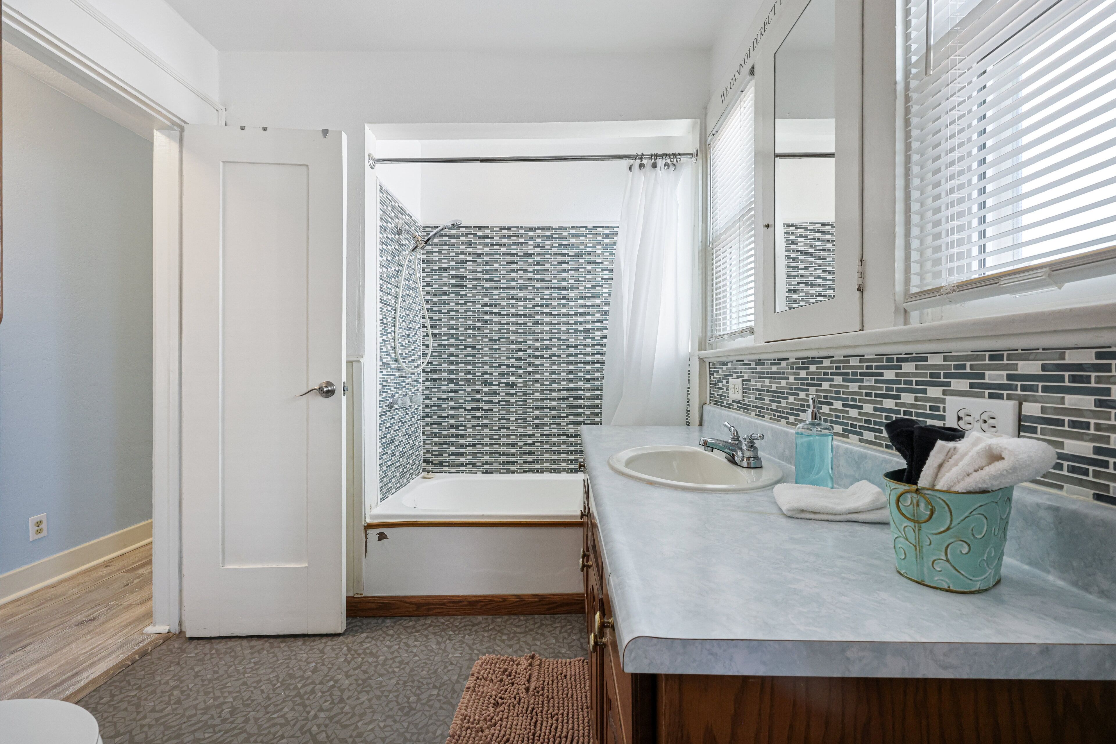 Ein Badezimmer mit Dusche, Waschbecken und Spiegel.