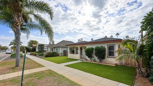 A residential house with a well-maintained lawn, a driveway, and a palm tree. - 2 br, 2 bth, fully fenced home - The Sunnyside Up Beach Cottage (Oceanside)
