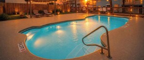 A swimming pool with a metal ladder, surrounded by a wooden fence, and a sign indicating a 3ft depth.