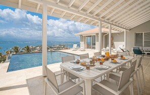 A dining area with a view of the sea and a pool. - Tangarane offers two luxury villas with private pools and exceptional views over (LES TROIS ILETS)