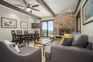 Relax in this stylish living room with a flat-screen TV, dining table, and comfortable sofa.